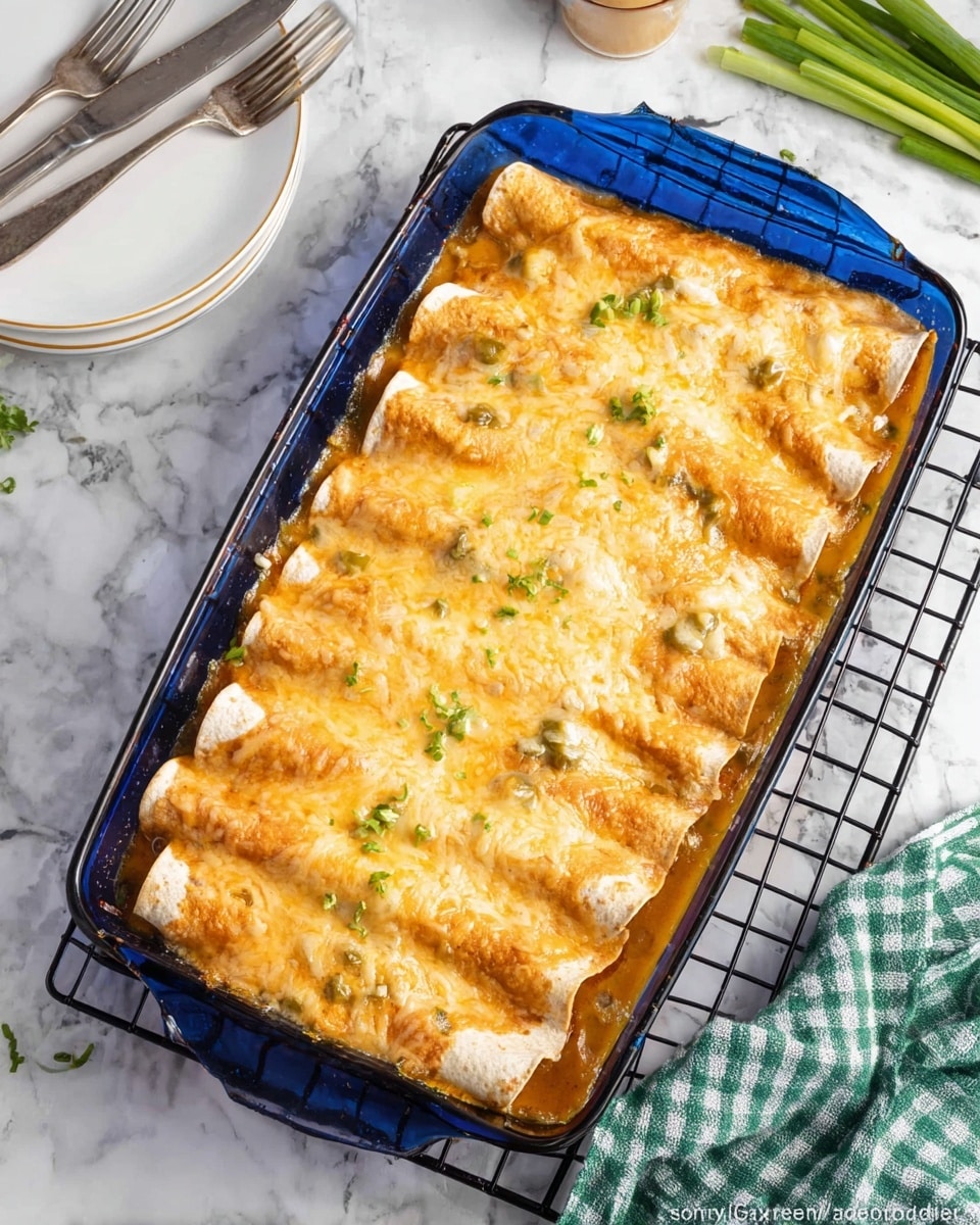 A blue glass rectangular baking dish holds six rolled enchiladas arranged in two rows. The enchiladas are covered with a bubbly melted cheese layer that has a light golden brown color, with small bits of green chilies visible underneath. The edges of the enchiladas show a slight browning, and underneath the cheese is a creamy sauce with a light orange tint, filling the bottom of the dish. The dish is placed on a black wire cooling rack atop a white marbled surface, with some green onions on the upper right and a green and white checkered cloth on the lower right side. Two white plates with silver forks are in the top left corner. Photo taken with an iphone --ar 4:5 --v 7