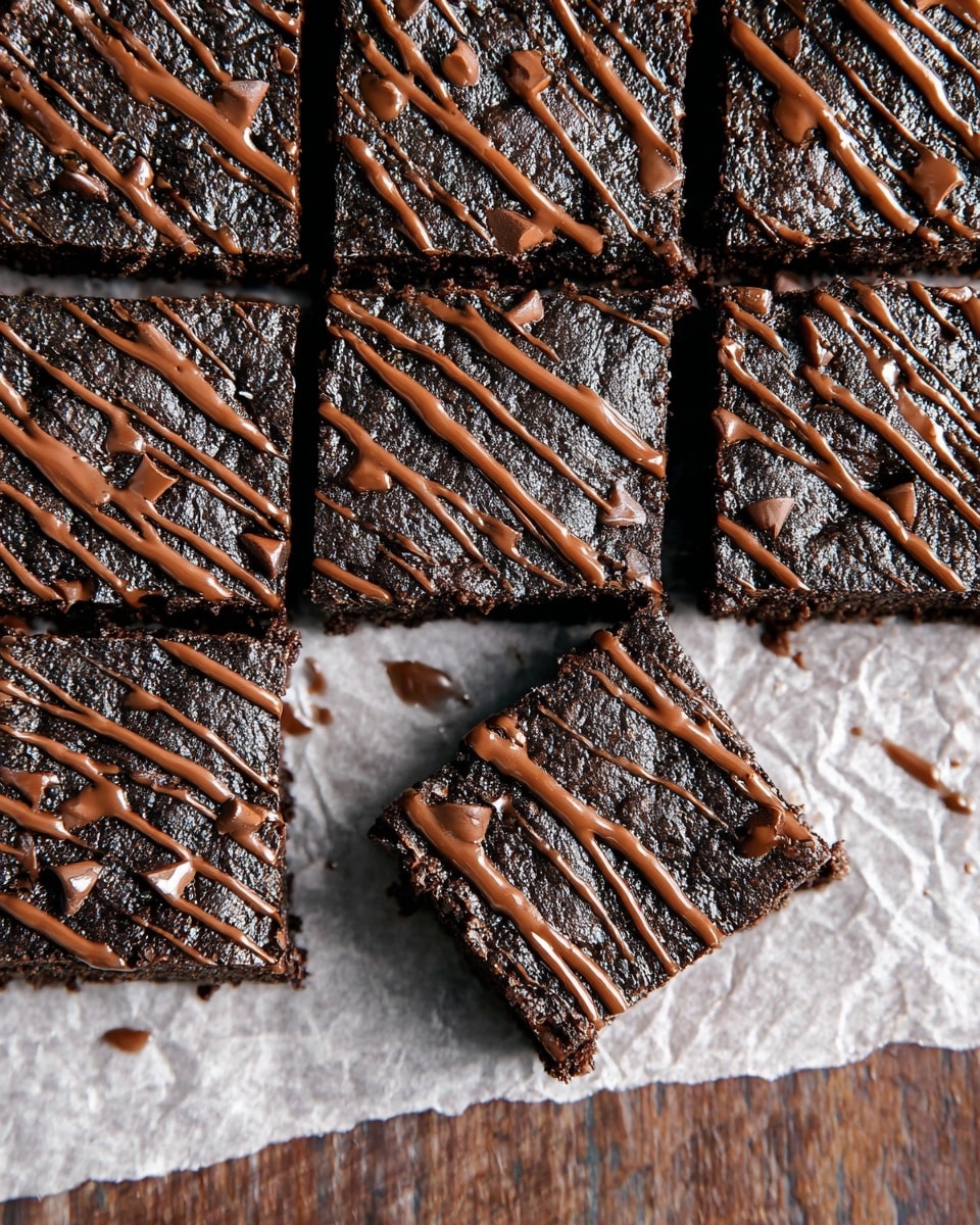 A grid of 12 dark chocolate brownies cut into squares with one square placed diagonally at the bottom right, all topped with thin drizzles of milk chocolate in a zigzag pattern, showing a moist and slightly crumbly texture. The brownies sit on a piece of semi-transparent white parchment paper over a white marbled surface. The contrast between the dark brown of the brownies and the light brown drizzle is clear, with some chocolate chips visible within the brownies. Photo taken with an iphone --ar 4:5 --v 7