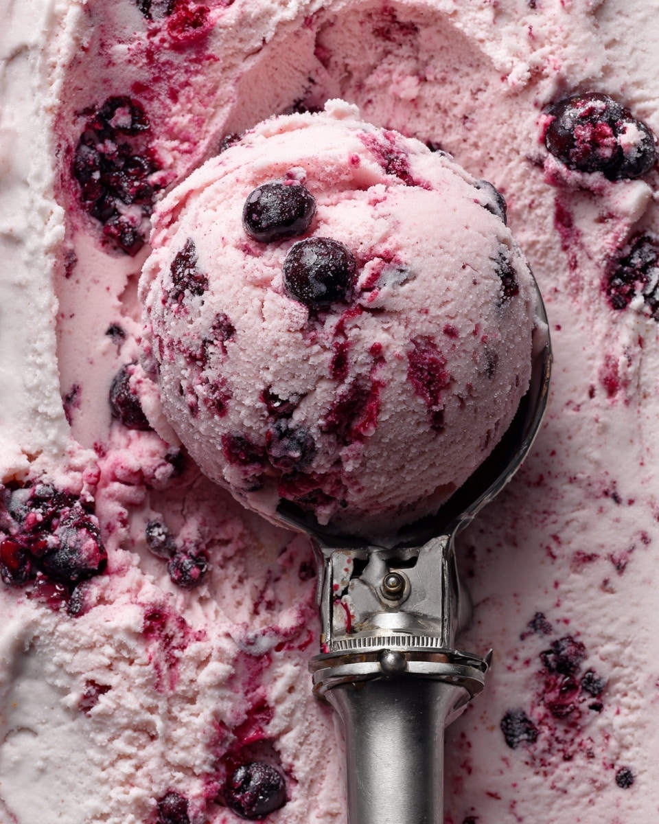 The image shows one scoop of creamy, swirled blackberry ice cream in a metal scoop. The ice cream has a soft pink base with darker purple and black swirls from the blackberries inside, creating a marbled effect. There are whole blackberries scattered throughout the ice cream, adding texture and deep colors. The metal scoop is placed on a white marbled surface covered with more of the same ice cream, with visible bits of blackberries spread around. The ice cream looks rich and fresh, with a slightly uneven, homemade texture. Photo taken with an iphone --ar 4:5 --v 7