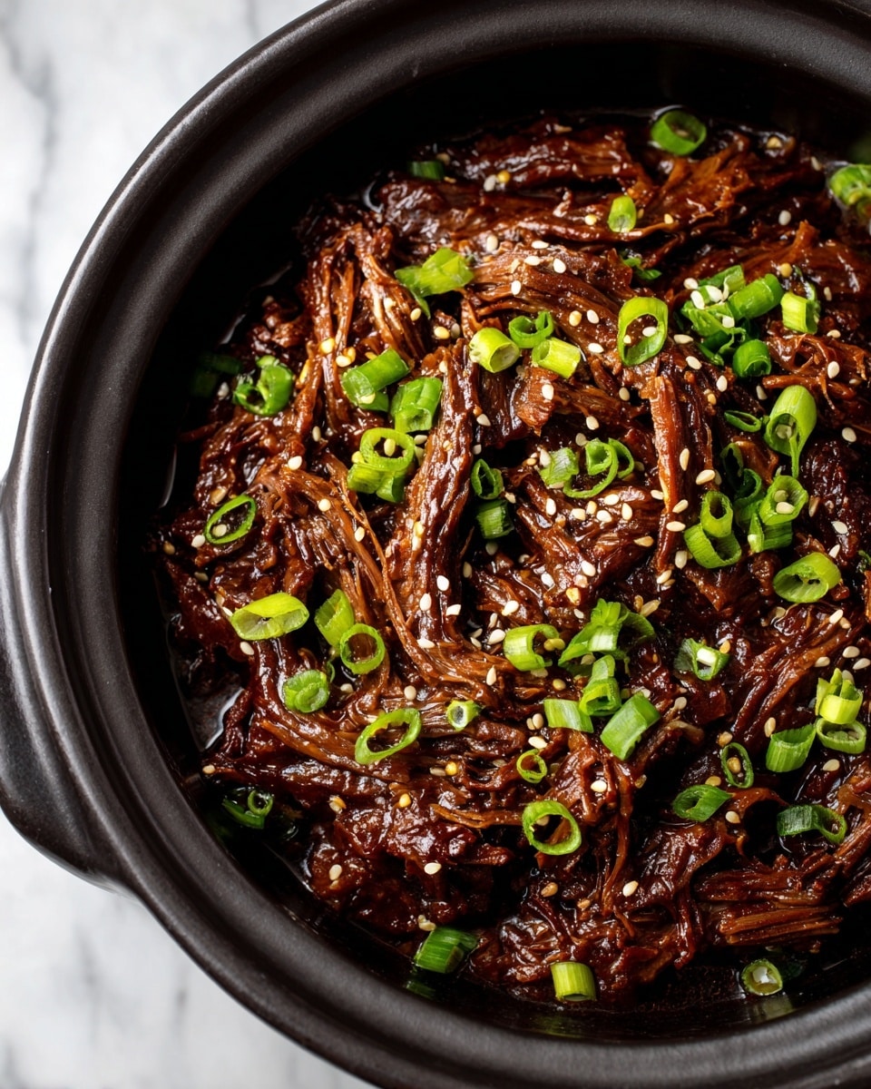 A black pot filled with shredded beef covered in a thick, dark brown sauce, topped with scattered bright green chopped scallions and small white sesame seeds, all sitting on a white marbled surface photo taken with an iphone --ar 4:5 --v 7