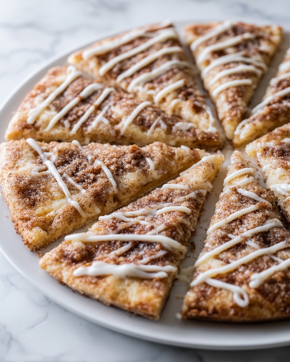 A round dessert pizza sliced into eight equal pieces on a white plate with a white marbled background. The bottom crust is golden brown and thin. The first layer is a light cream cheese or glaze spread evenly. On top, there is a layer of cinnamon sugar that looks grainy and brown, covering each slice. Drizzled in diagonal lines across the whole pizza is a white icing or glaze, adding contrast to the brown cinnamon sugar. The pizza has a warm, baked look with a slightly crispy edge. photo taken with an iphone --ar 4:5 --v 7