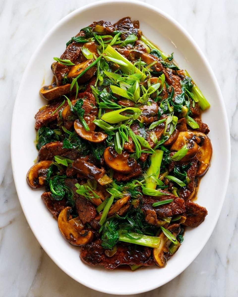 A close-up of a white oval plate filled with a glossy, dark brown stir-fry dish. The dish has thick layers of shiny, sauce-coated slices of tempeh mixed with light brown, slightly curved mushroom pieces, and several light green, firm stalks of scallions scattered evenly throughout. The sauce glistens under the light, creating a rich, moist texture over the tempeh and mushrooms. The plate sits on a white marbled surface, with the ingredients piled in a way that shows their varied shapes and textures clearly. photo taken with an iphone --ar 4:5 --v 7