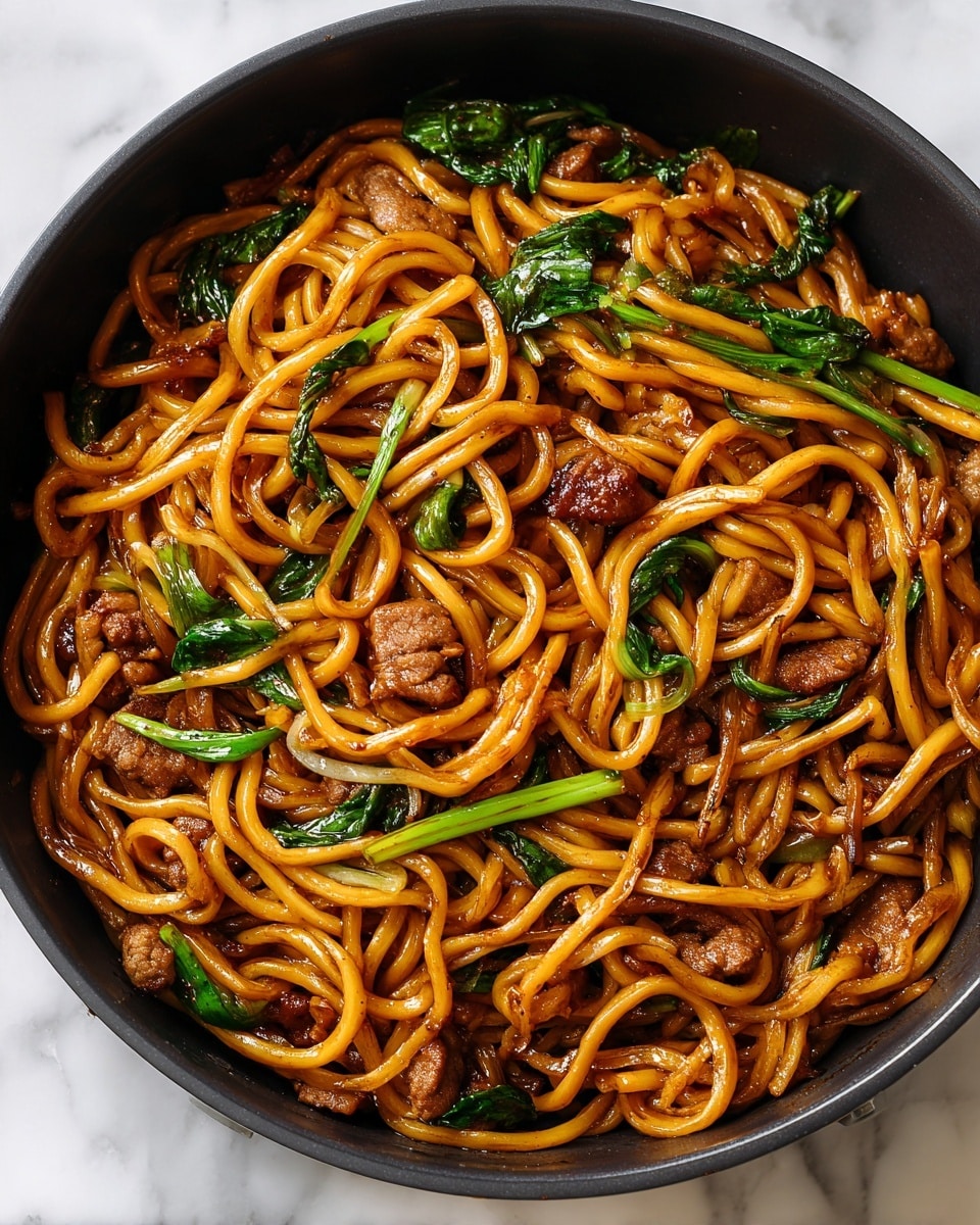 A close-up view of a dish in a white bowl filled with thick, golden brown udon noodles coated in a shiny dark sauce. There are pieces of tender cooked meat mixed throughout the noodles, each piece showing a rich brown color and slightly glossy texture. Bright green leaves of cooked spinach are scattered on the sides, adding a fresh contrast to the dark noodles and meat. The sauce glistens on the noodles, making the dish look moist and flavorful. The bowl sits on a white marbled surface, showing some sauce droplets around, enhancing the fresh-cooked feeling. Photo taken with an iphone --ar 4:5 --v 7